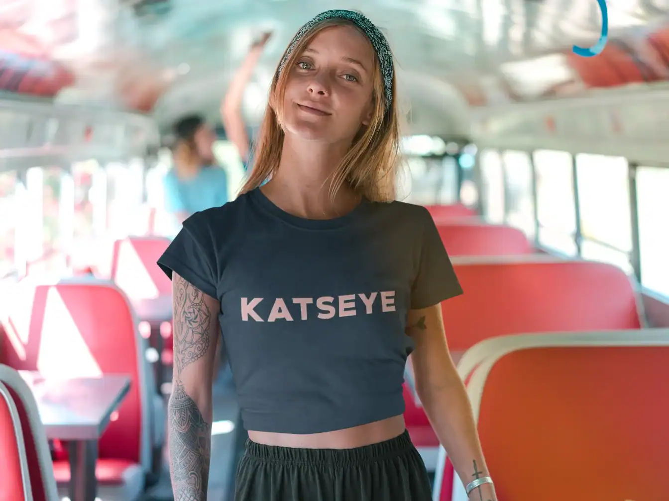 model wearing blue katseye t-shirt inside a bus