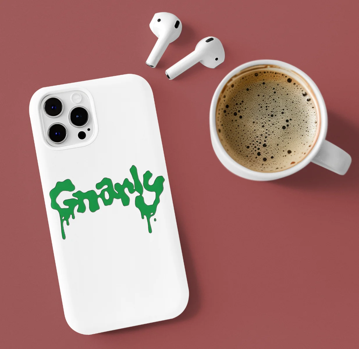 Katseye Gnarly Phone Case made of soft TPU Silicone next to apple airpods and a cup of coffee